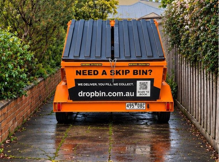 DropBin trailer in a narrow side driveway between a brick wall and a timber fence